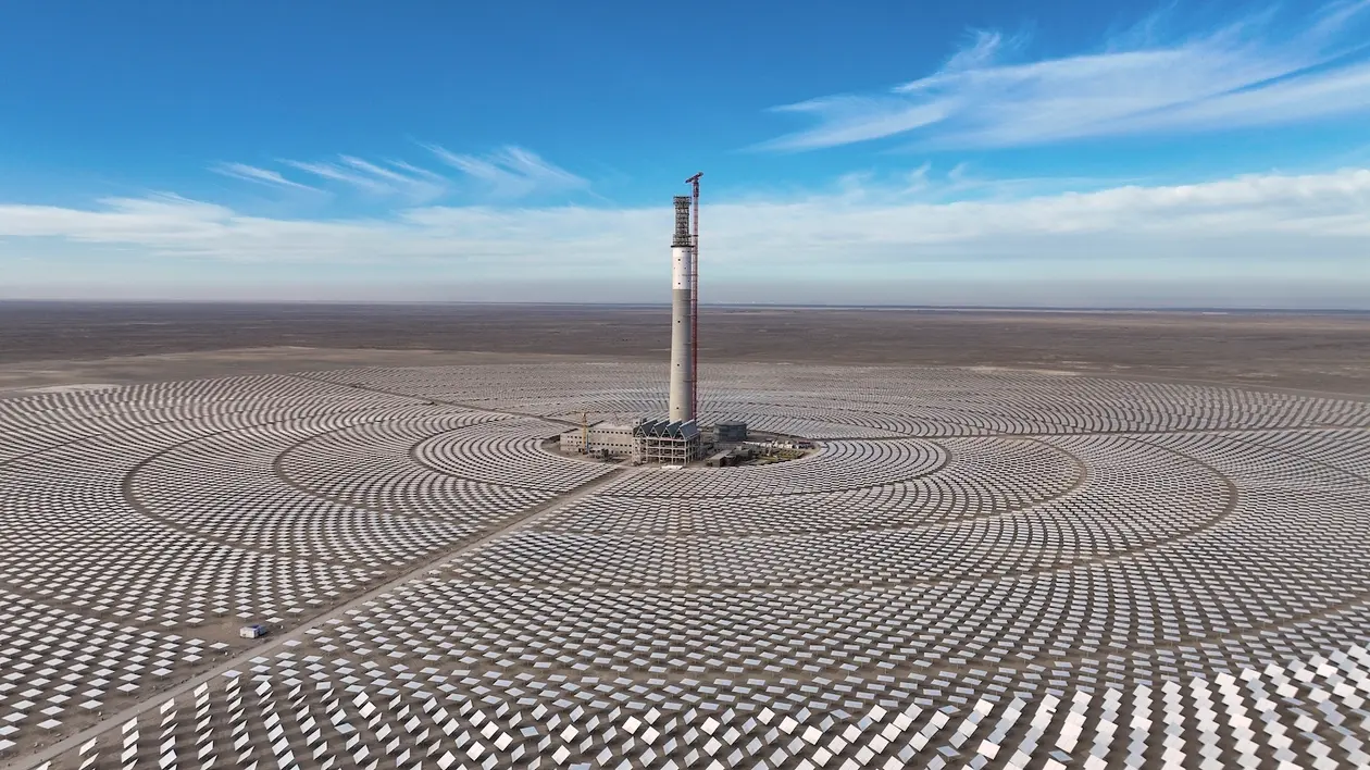 A panoramic view of a large solar farm in rural China, with rows of blue photovoltaic panels stretching across open land under clear skies, symbolising the country’s rapid expansion in renewable energy.